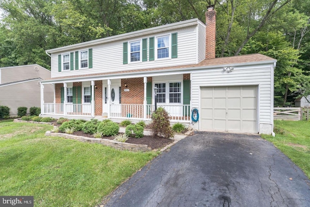 view of front of property with a garage, covered porch, and a front lawn