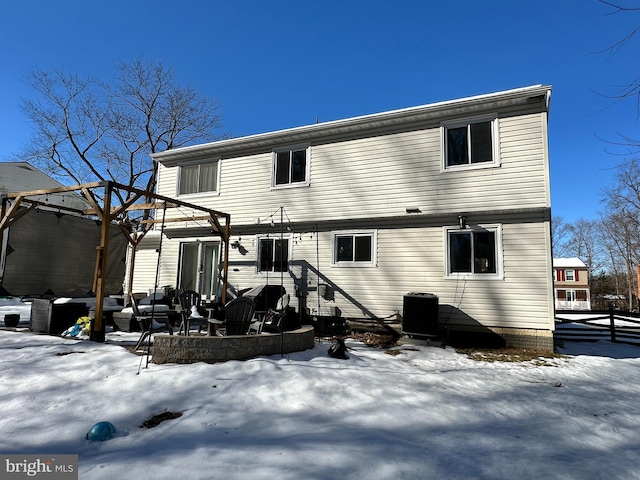 snow covered house featuring central air condition unit