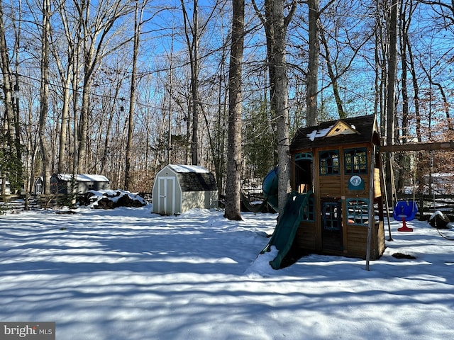 yard covered in snow featuring a playground