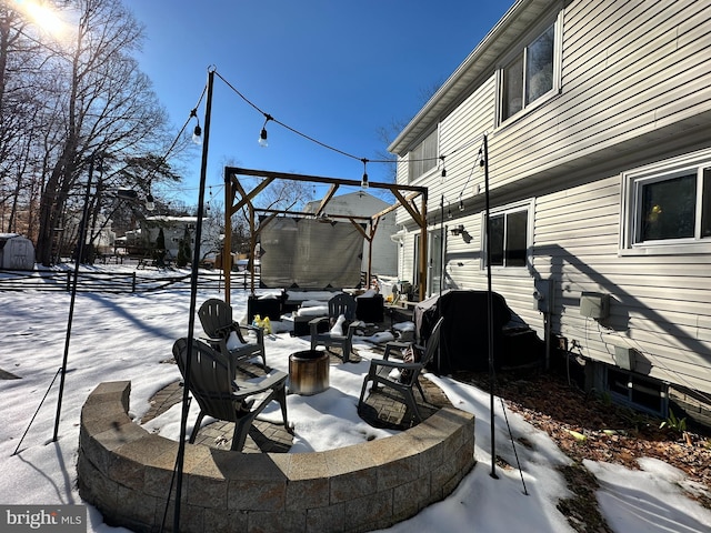 snow covered patio featuring a fire pit