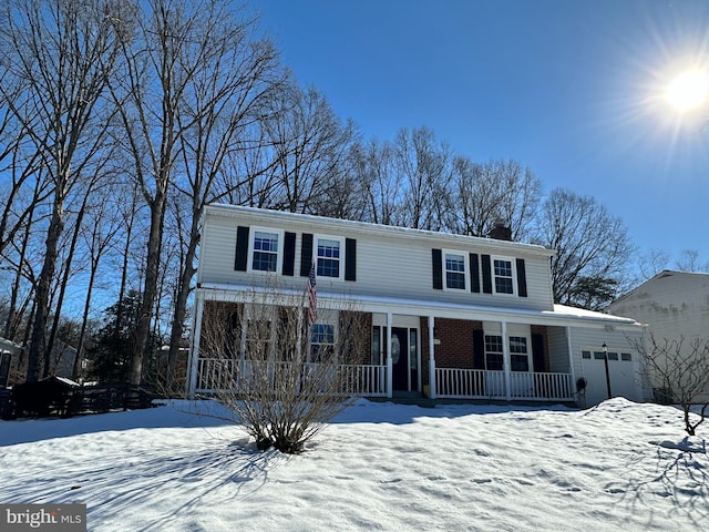 front facade featuring covered porch and a garage