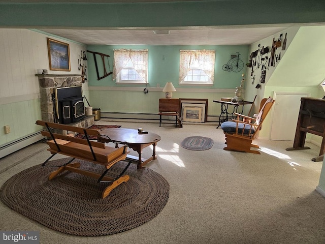 living area with carpet flooring, a wood stove, and a baseboard heating unit