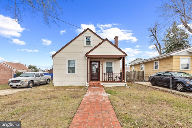 bungalow with covered porch and a front yard