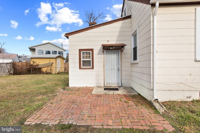 doorway to property with a patio area and a yard