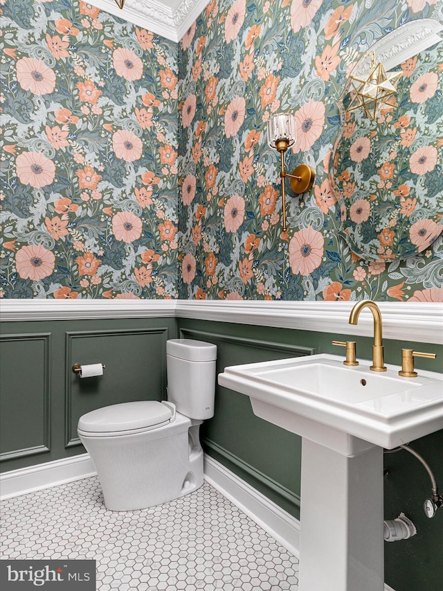 bathroom featuring tile patterned flooring, toilet, and crown molding