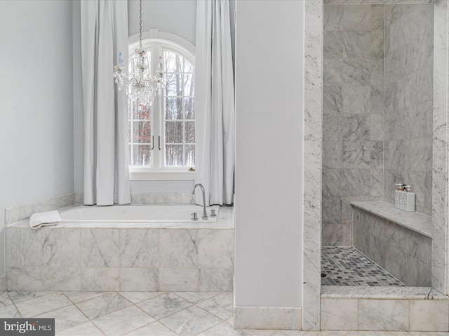 bathroom featuring tiled bath and an inviting chandelier