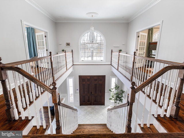 foyer entrance featuring a notable chandelier and ornamental molding