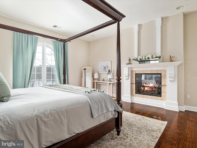 bedroom featuring a fireplace and dark hardwood / wood-style flooring