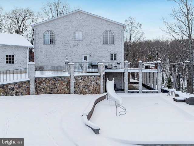 view of snow covered back of property