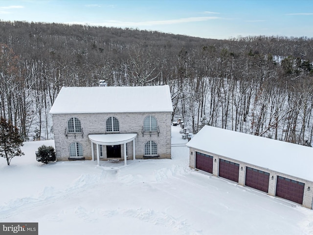 view of snow covered back of property