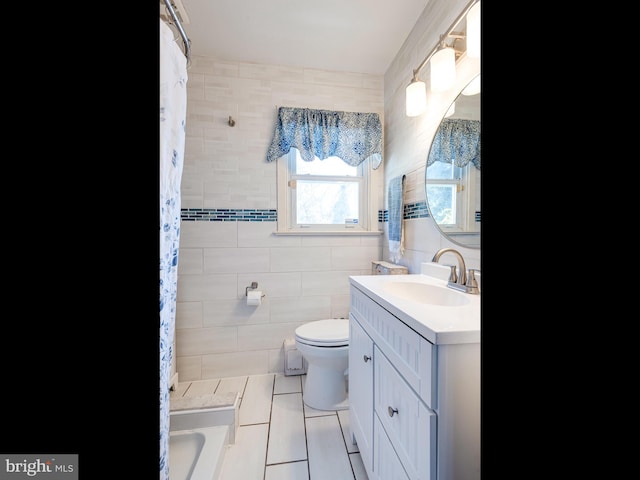 bathroom featuring tile patterned flooring, vanity, toilet, and tile walls