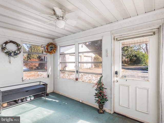 sunroom / solarium featuring ceiling fan, a healthy amount of sunlight, and wooden ceiling