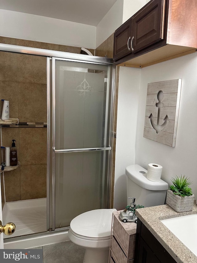 bathroom featuring vanity, toilet, and an enclosed shower