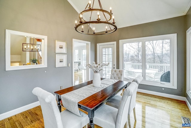 dining area featuring plenty of natural light, light hardwood / wood-style floors, french doors, and a chandelier