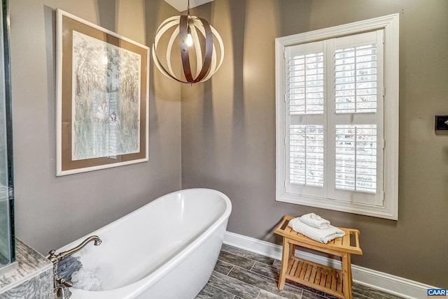 bathroom featuring a chandelier and a tub