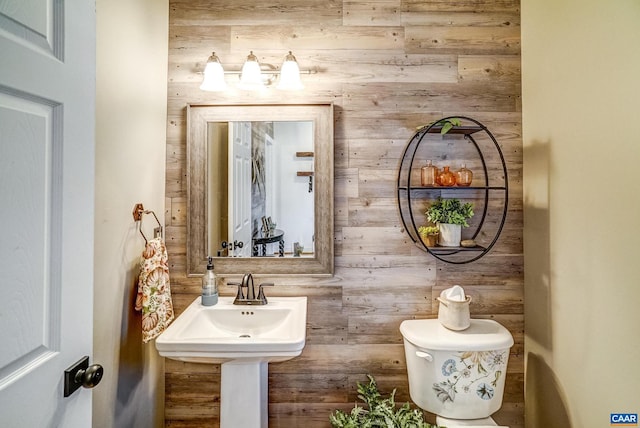 bathroom with toilet and wooden walls