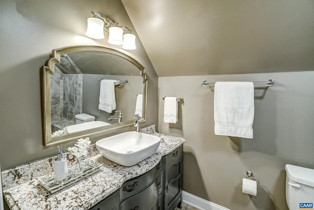 bathroom featuring vanity, toilet, and lofted ceiling