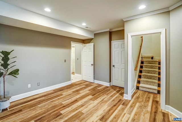 basement featuring ornamental molding and light hardwood / wood-style flooring