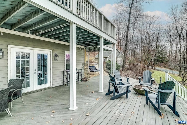 wooden deck with french doors and an outdoor fire pit