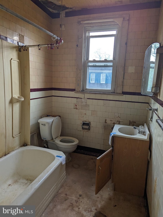 bathroom with vanity, toilet, and tile walls