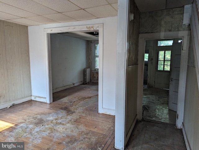 corridor with a paneled ceiling and radiator