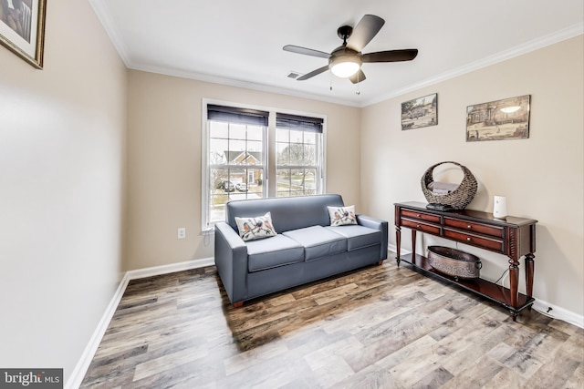 living area with hardwood / wood-style flooring, ceiling fan, and ornamental molding