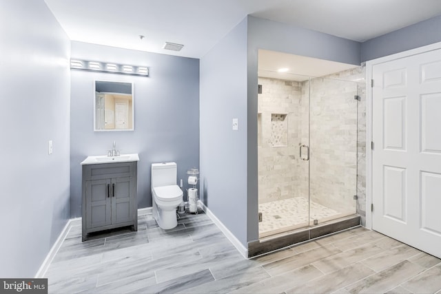 bathroom featuring vanity, toilet, and a shower with door