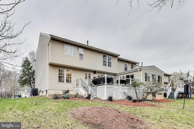 rear view of property with a lawn, cooling unit, and a deck