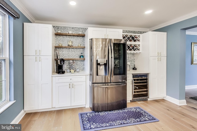 bar with white cabinets, stainless steel fridge, beverage cooler, and light hardwood / wood-style flooring