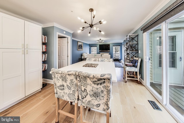 kitchen featuring an inviting chandelier, white cabinetry, crown molding, and light hardwood / wood-style flooring