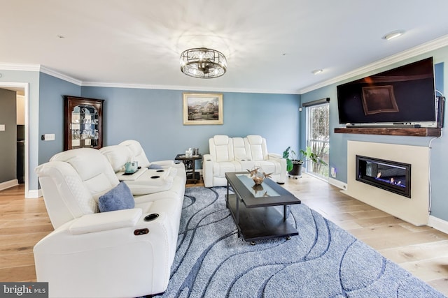 living room with light wood-type flooring, ornamental molding, and a chandelier