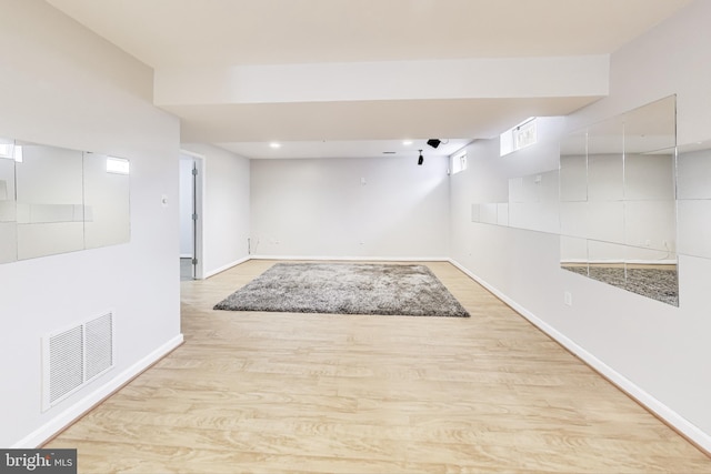 basement with light hardwood / wood-style flooring