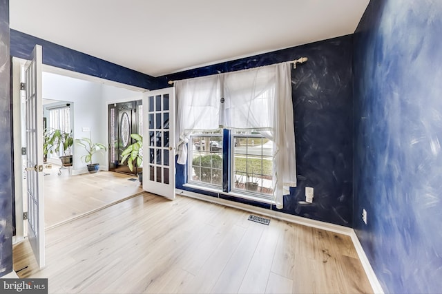 unfurnished room featuring french doors and hardwood / wood-style floors