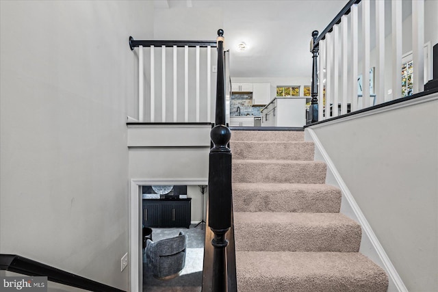 stairway featuring plenty of natural light and sink