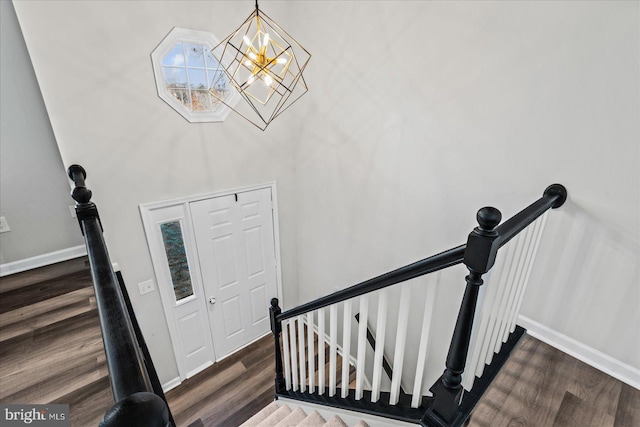 stairs with a chandelier and wood-type flooring