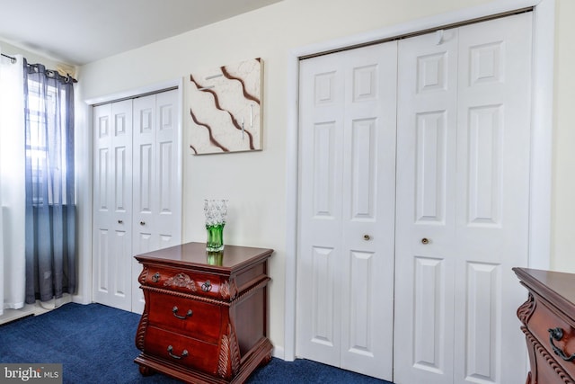 carpeted bedroom featuring two closets