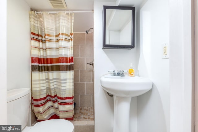 bathroom featuring a shower with curtain and toilet