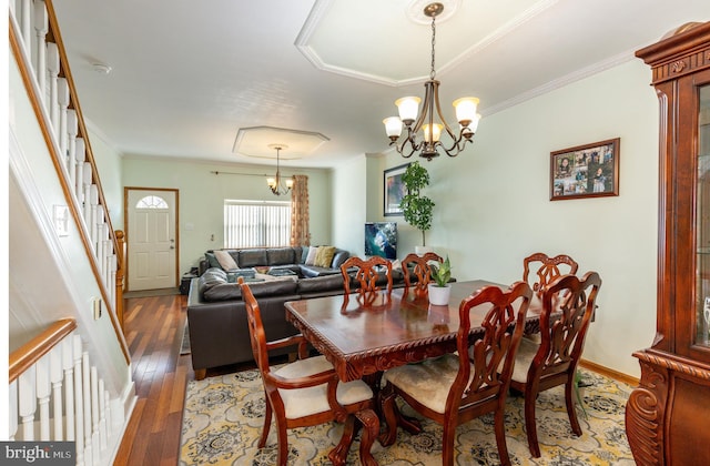 dining space with ornamental molding, dark hardwood / wood-style floors, and an inviting chandelier