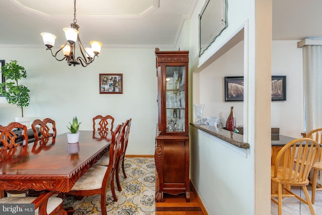 dining space with light wood-type flooring, an inviting chandelier, and crown molding