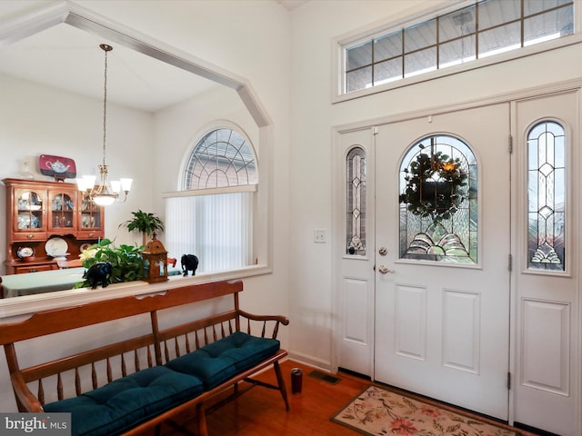 foyer with wood-type flooring and a notable chandelier