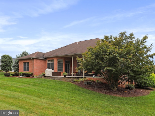 back of property with a lawn and a patio area