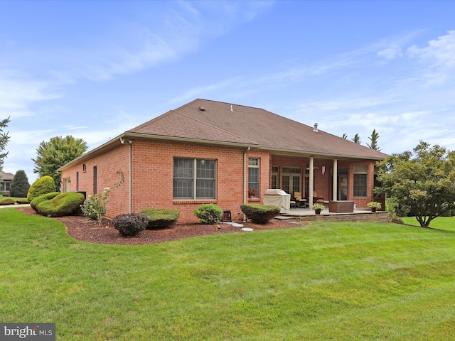 back of property featuring a patio and a lawn