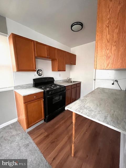 kitchen with sink, dark hardwood / wood-style floors, and black range with gas cooktop