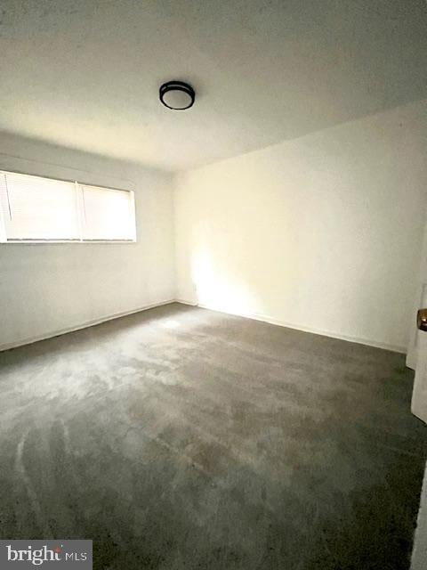 unfurnished room with dark colored carpet