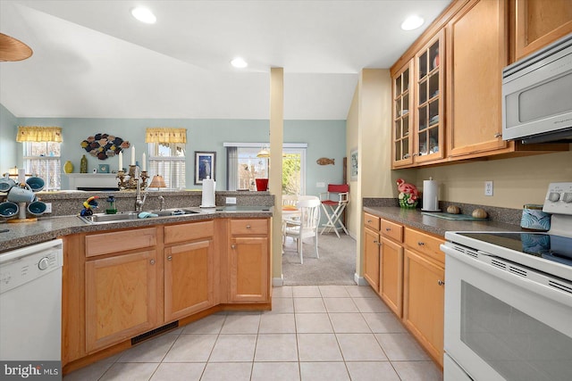 kitchen featuring vaulted ceiling, a wealth of natural light, sink, and white appliances