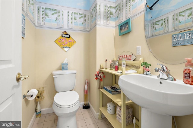 bathroom with toilet, tile patterned floors, and sink