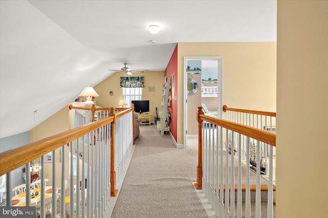 hall featuring light carpet and vaulted ceiling