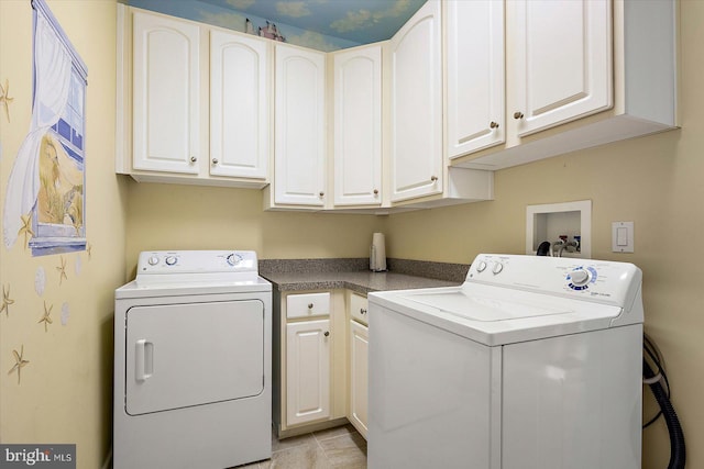 laundry room with cabinets, light tile patterned floors, and separate washer and dryer