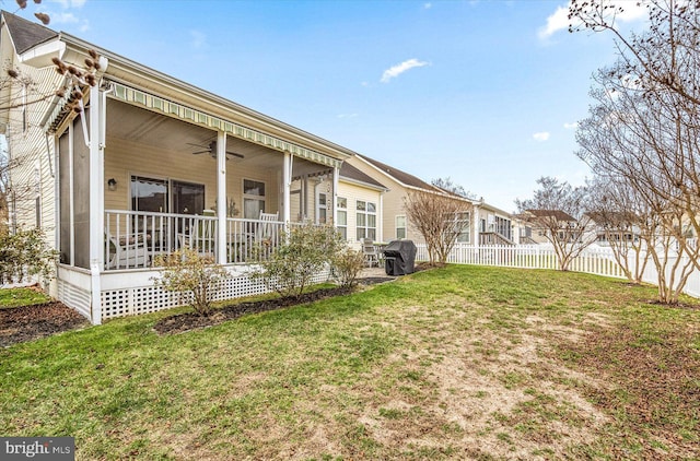 rear view of property featuring a yard and ceiling fan