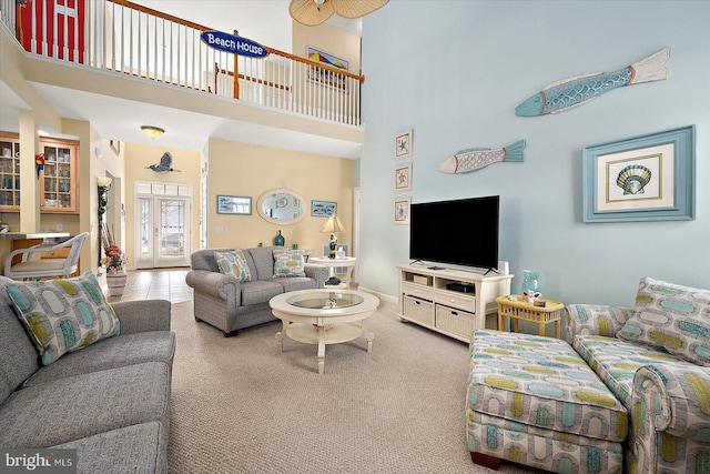 carpeted living room with french doors and a high ceiling